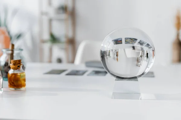 Sfera di vetro vicino forniture stregoneria offuscata sul tavolo — Foto stock