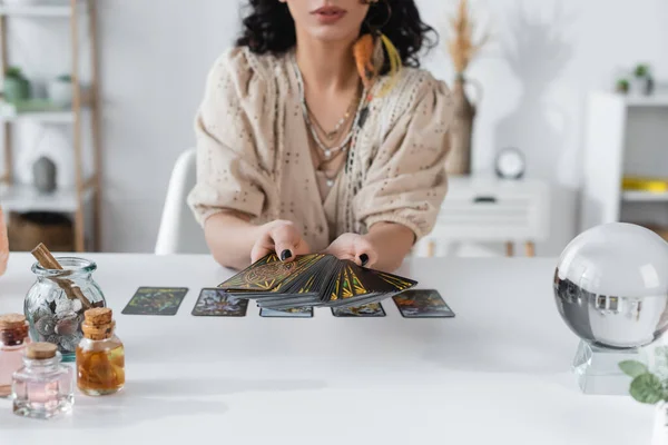 KYIV, UKRAINE - FEBRUARY 23, 2022: Cropped view of tarot cards in hands of blurred medium — Foto stock