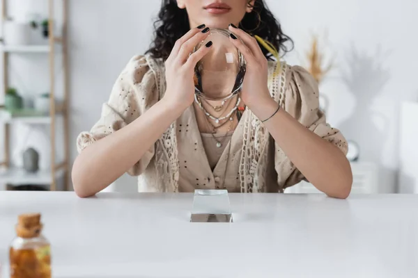 Cropped view of fortune teller holding orb at home - foto de stock