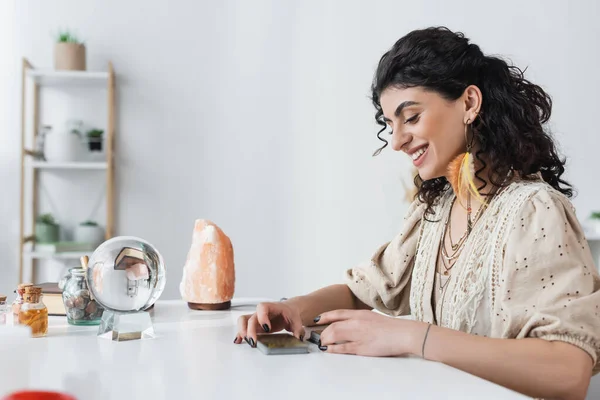 Lächelnde Zigeuner-Wahrsagerin betrachtet Tarot-Karten zu Hause — Stockfoto