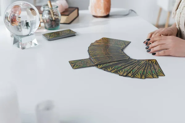 KYIV, UKRAINE - FEBRUARY 23, 2022: Cropped view of tarot cards and orb near fortune teller - foto de stock