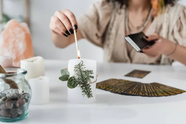 Vue recadrée de la bougie à combustion moyenne près des cartes de tarot sur la table — Photo de stock