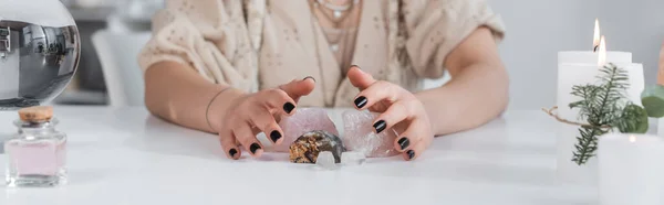 Ausgeschnittene Ansicht des Wahrsagers mit magischen Kristallen in der Nähe von Kerzen und Kugeln auf dem Tisch, Banner — Stockfoto