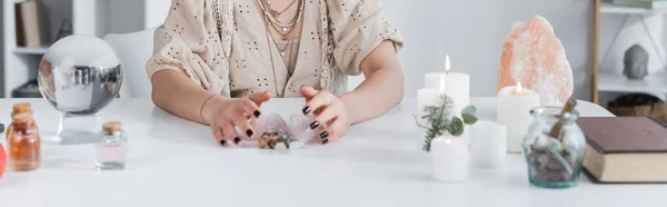 Ausgeschnittene Ansicht von mittelgroßen Kristallen in der Nähe von Kerzen und magischen Kugeln zu Hause, Banner — Stockfoto