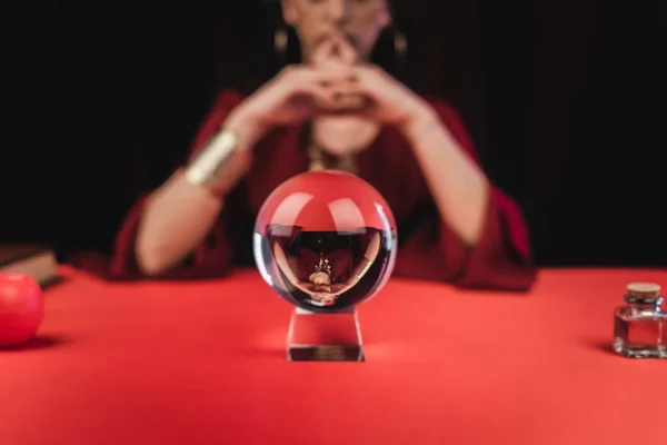 Cropped view of magic orb near blurred fortune teller isolated on black — Stock Photo