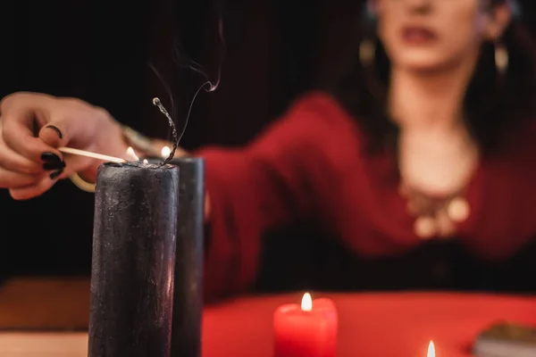 Cropped view of blurred medium burning candle isolated on black — Fotografia de Stock