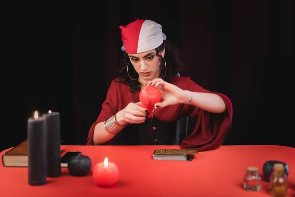 Gypsy medium burning candles near tarot cards isolated on black — Foto stock