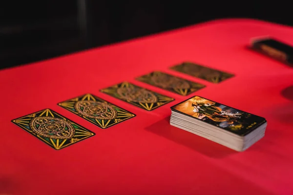 KYIV, UCRANIA - 23 DE FEBRERO DE 2022: Cartas de tarot sobre mesa roja aisladas sobre negro - foto de stock