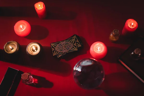 KYIV, UKRAINE - FEBRUARY 23, 2022: top view of tarot cards near candles and witchcraft supplies on table - foto de stock