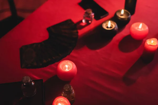 Draufsicht auf Gläser und brennende Kerzen auf verschwommenem Tisch — Stockfoto