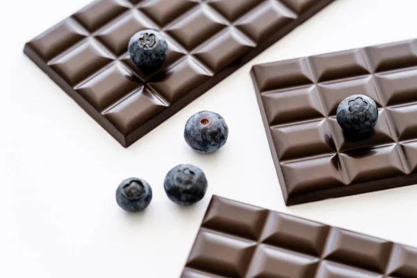 Close up view of blueberries and chocolate bars on white background — Stock Photo