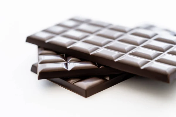 Close up view of bars of dark chocolate on white background — Stock Photo