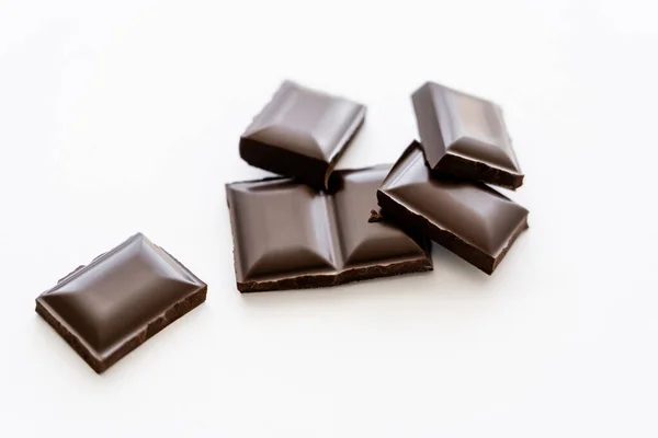 Vista da vicino di pezzi di cioccolato su sfondo bianco — Foto stock