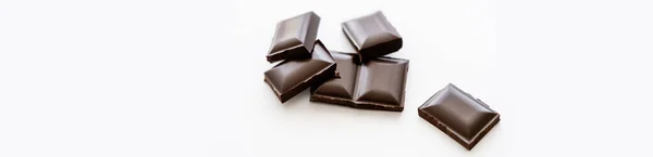 Pedaços de chocolate escuro no fundo branco com espaço de cópia, banner — Fotografia de Stock