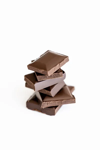 Vista da vicino di pezzi di cioccolato al latte isolati su bianco — Foto stock