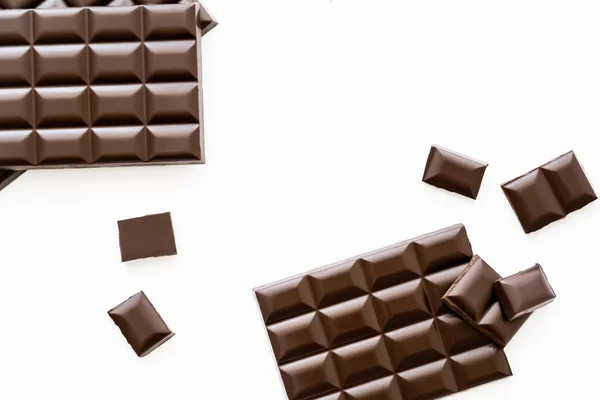 Вид зверху на шоколадні батончики і шматки ізольовані на білому — стокове фото