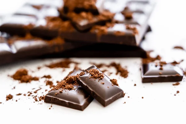 Close up view brown chocolate pieces and cocoa on white background — Fotografia de Stock