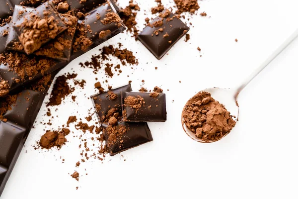 Top view of dark chocolate and cocoa in spoon on white background — Fotografia de Stock