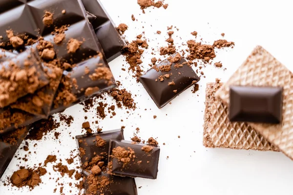 Top view of cocoa powder on chocolate and waffles on white background - foto de stock