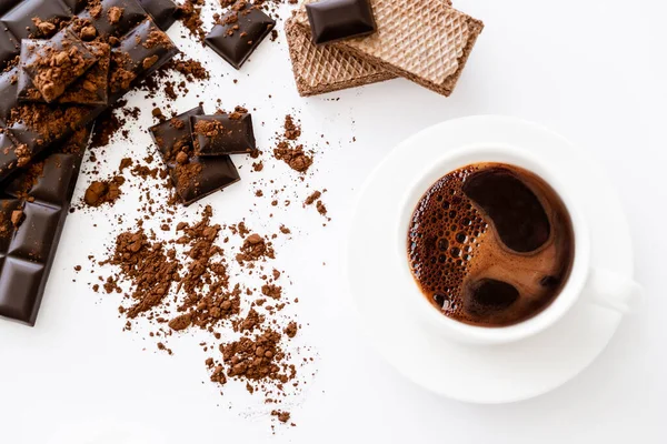 Top view of coffee in cup, waffles and dark chocolate on white background — Stockfoto