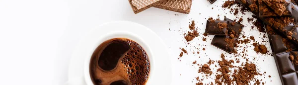 Draufsicht auf Tasse Kaffee, Waffeln und braune Schokolade auf weißem Hintergrund, Banner — Stockfoto