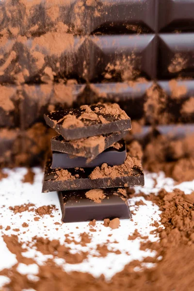 Close up view of cocoa powder and dark chocolate on white background - foto de stock