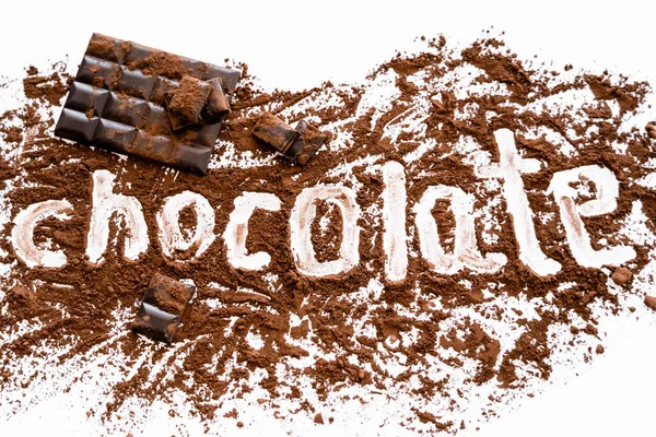 Vista superior de letras de chocolate em cacau perto da barra no fundo branco — Fotografia de Stock