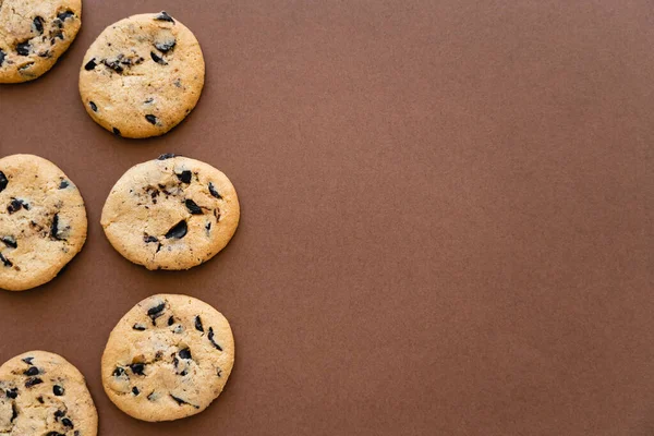 Top view of cookies with chocolate on brown background with copy space — стоковое фото