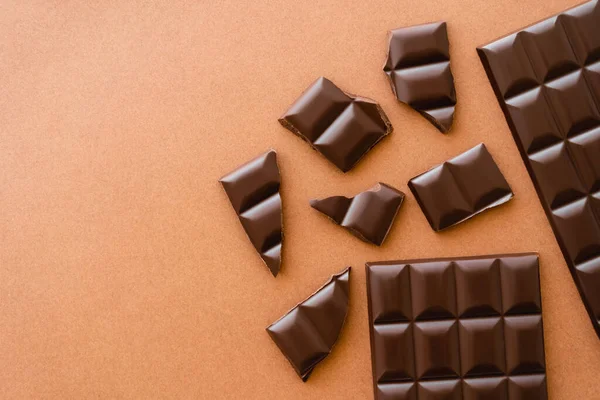 Vue du dessus du chocolat noir sur fond brun avec espace de copie — Photo de stock