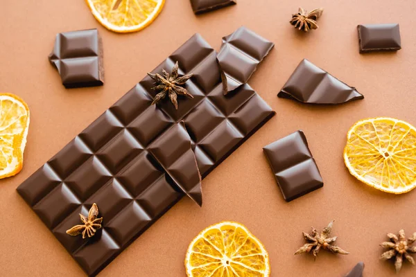 Top view of chocolate, dry orange slices and anise on brown background — Foto stock