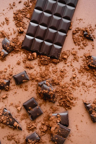 Top view of natural dark chocolate and cocoa on brown background — Stockfoto