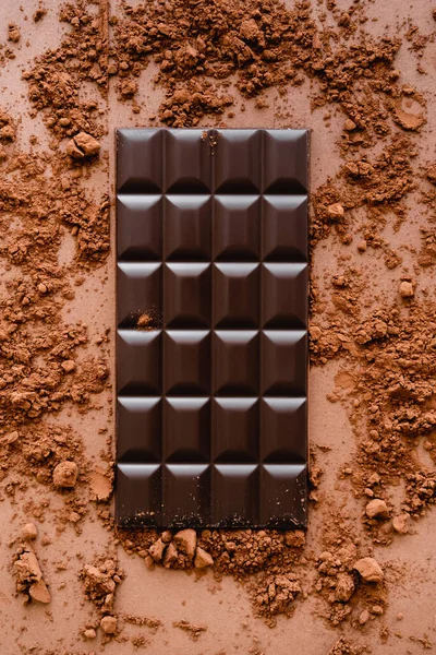 Вид зверху на темний шоколадний бар і какао на коричневому фоні — стокове фото