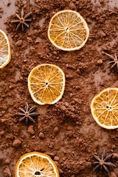 Top view of dry orange slices and anise on cocoa on brown background - foto de stock