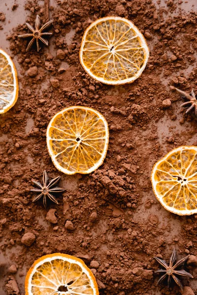 Vue de dessus de tranches d'orange sèches et d'anis sur cacao sur fond brun — Photo de stock