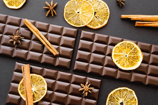 Top view of cinnamon and anise on chocolate bars on black background — Foto stock