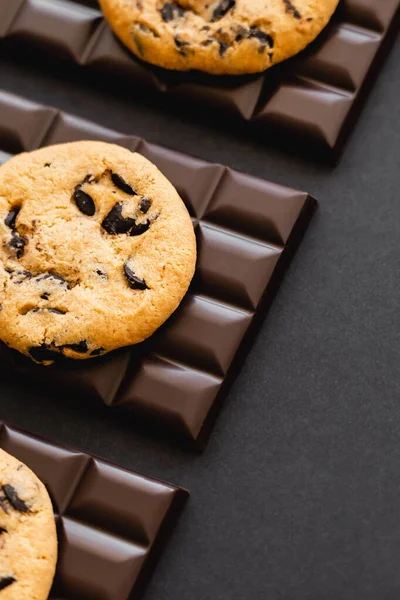 Top view of delicious cookies on dark chocolate on black surface — Stock Photo