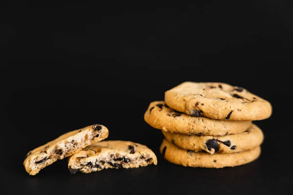 Close up view of cookies with chocolate chips on black background — Stock Photo