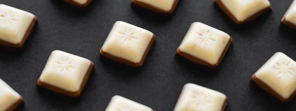 Vista de perto de pedaços de chocolate branco e leite na superfície preta, banner — Fotografia de Stock