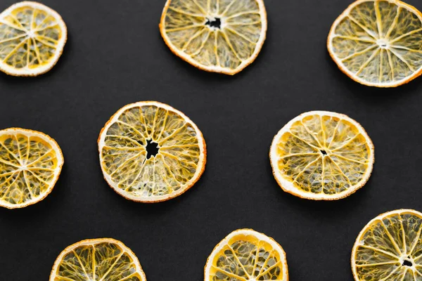 Вид зверху на сухі апельсинові скибочки на чорному тлі — стокове фото