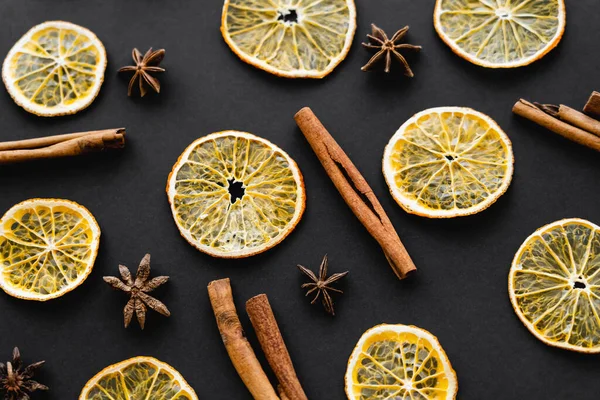 Vista superior de fatias de laranja seca, canela e anis sobre fundo preto — Fotografia de Stock