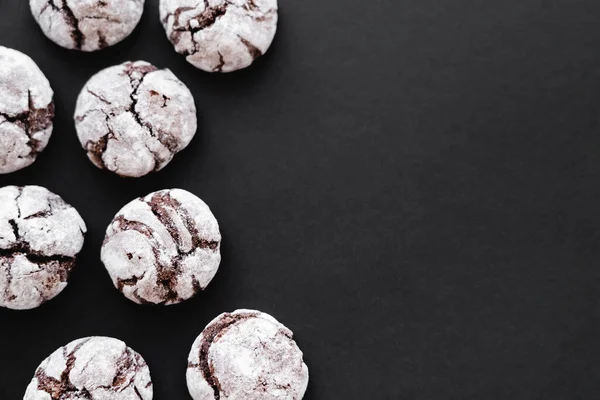 Top view of cookies with powdered sugar on black background - foto de stock