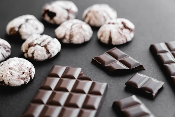 Close up view of chocolate bars and biscuits on black background — Photo de stock