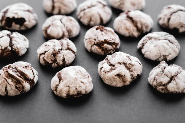 Vista de cerca de deliciosas galletas con azúcar en polvo sobre fondo negro - foto de stock