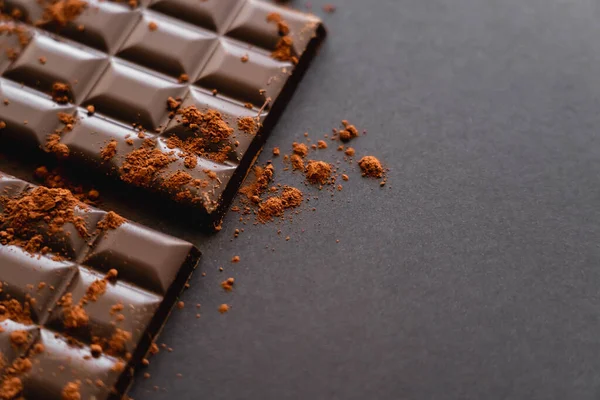 Close up view of natural cocoa on chocolate on black background with copy space — Stock Photo