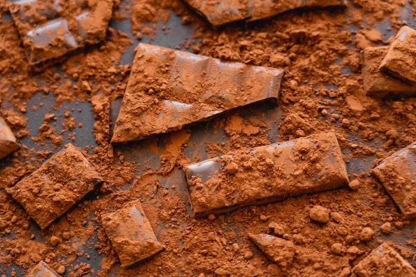 Draufsicht auf natürliche Schokolade und Kakao auf schwarzem Hintergrund — Stockfoto