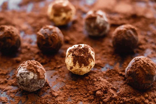 Close up view of tasty candies with cocoa on black background — Photo de stock