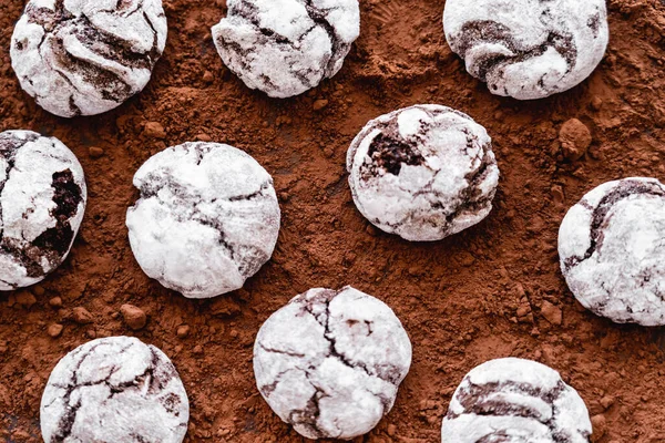 Vista superior de las galletas con azúcar en polvo en la superficie del cacao - foto de stock