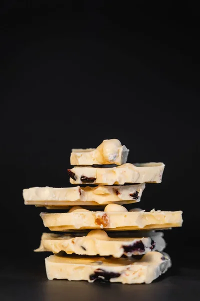 Close up view of white chocolate with nuts on black background — Photo de stock