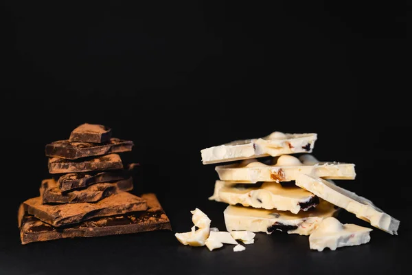 White and dark chocolate with dry cocoa on black background — Photo de stock