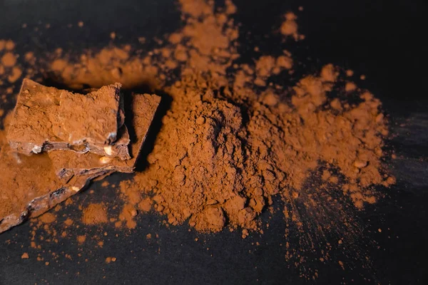 Vue du dessus du chocolat et du cacao en poudre sur la surface noire — Photo de stock